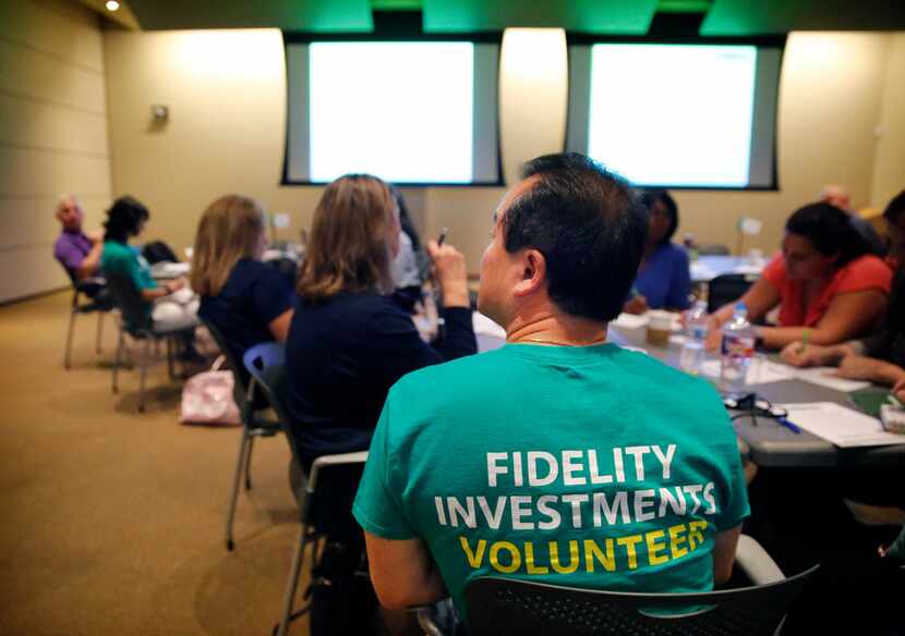 Local high school teachers with the assistance of Fidelity Investments volunteers attend a...