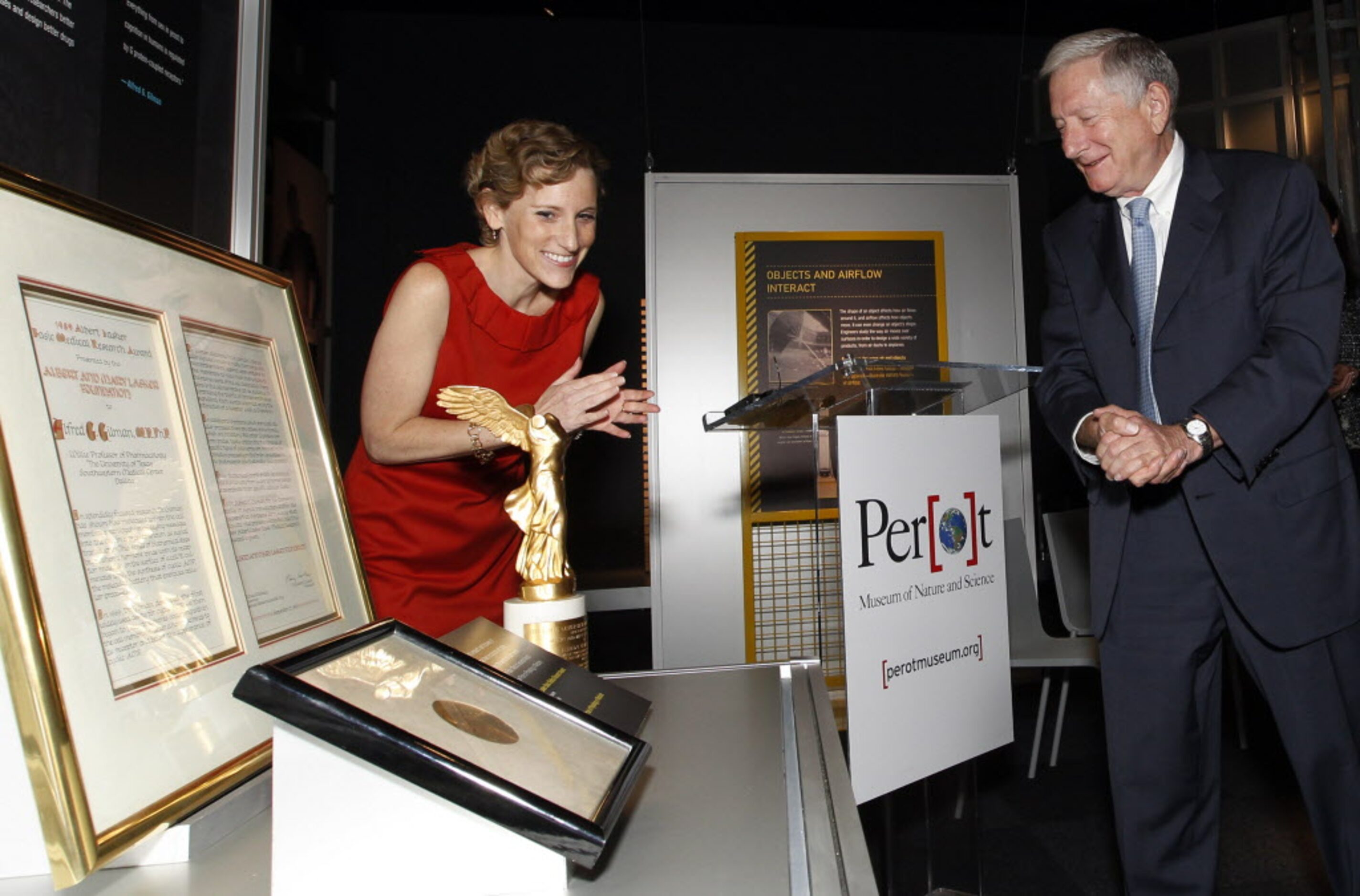 Nicole G. Small, CEO of Eugene McDermott, left, applauds as Dr. Alfred Gilman reacts after...