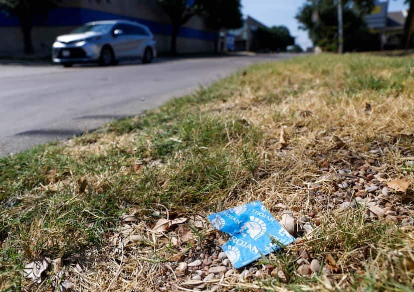 A condom wrapper sits on the side of the road along Shady Trail in Dallas on Wednesday, Aug....