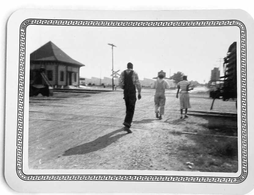 Three unidentified Black workers crossed the tracks near the railroad depot in Corsicana in...