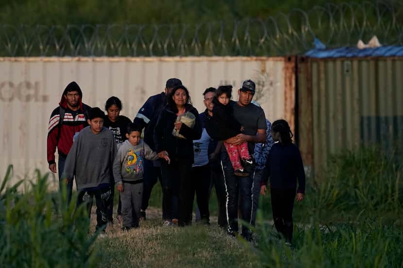 Migrants walk past a barrier after they crossed the Rio Grande and entered the U.S. from...
