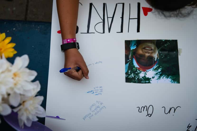 A vigil attendee signs a poster in honor of Kaytlynn Cargill at Central Junior High School...