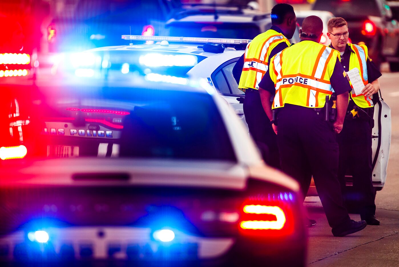 Dallas police officer Bryan Madden (right) works the scene of a traffic accident at Skillman...