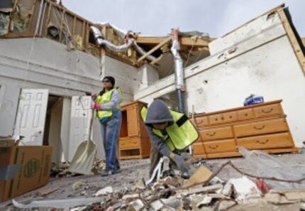  Volunteers Beatriz Rivera, left, and her 5-year-old son Kellan Rivera, clean up debris at a...