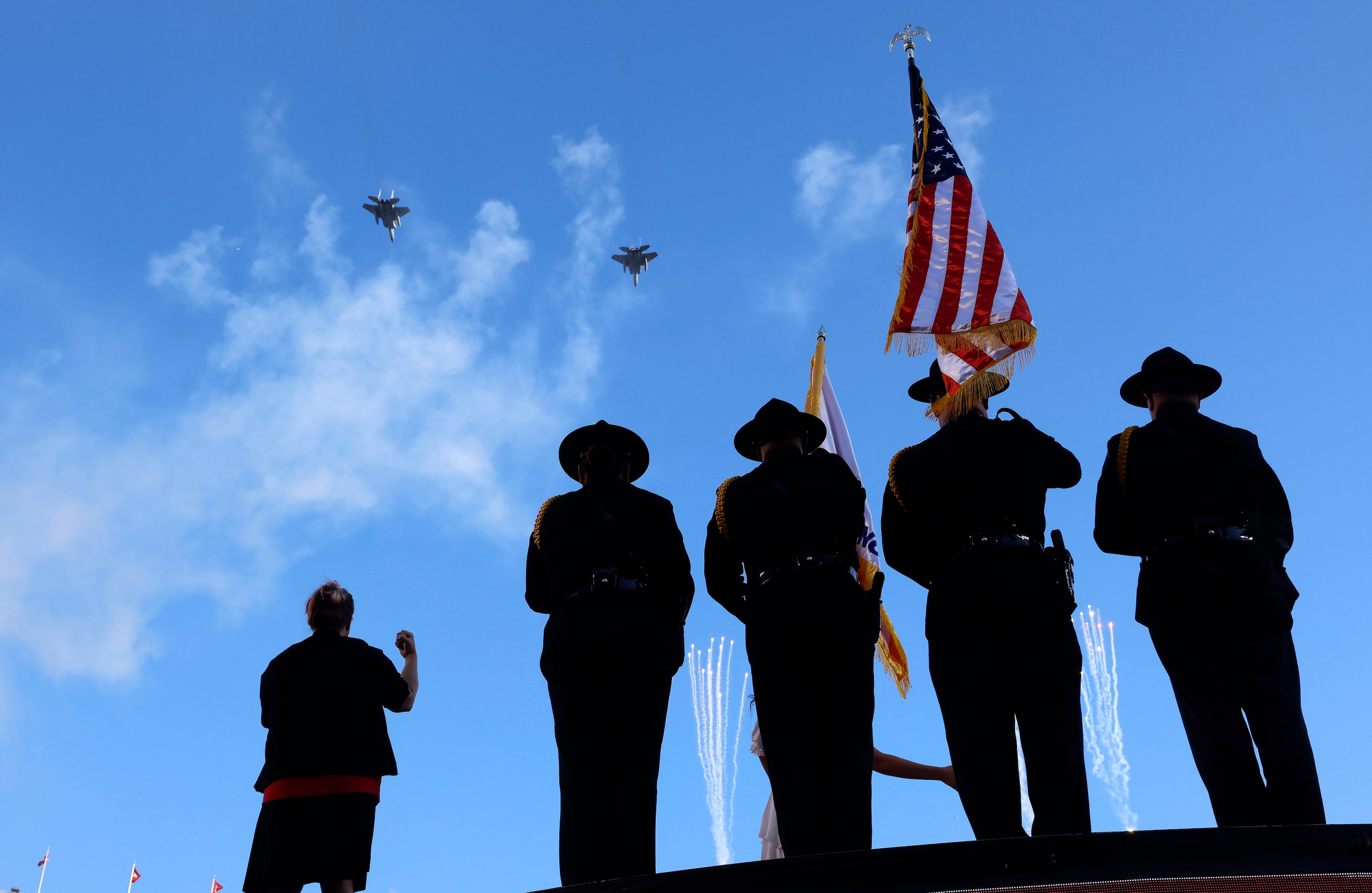 A pair of military aircraft perform a flyover during the national anthem before the Dallas...