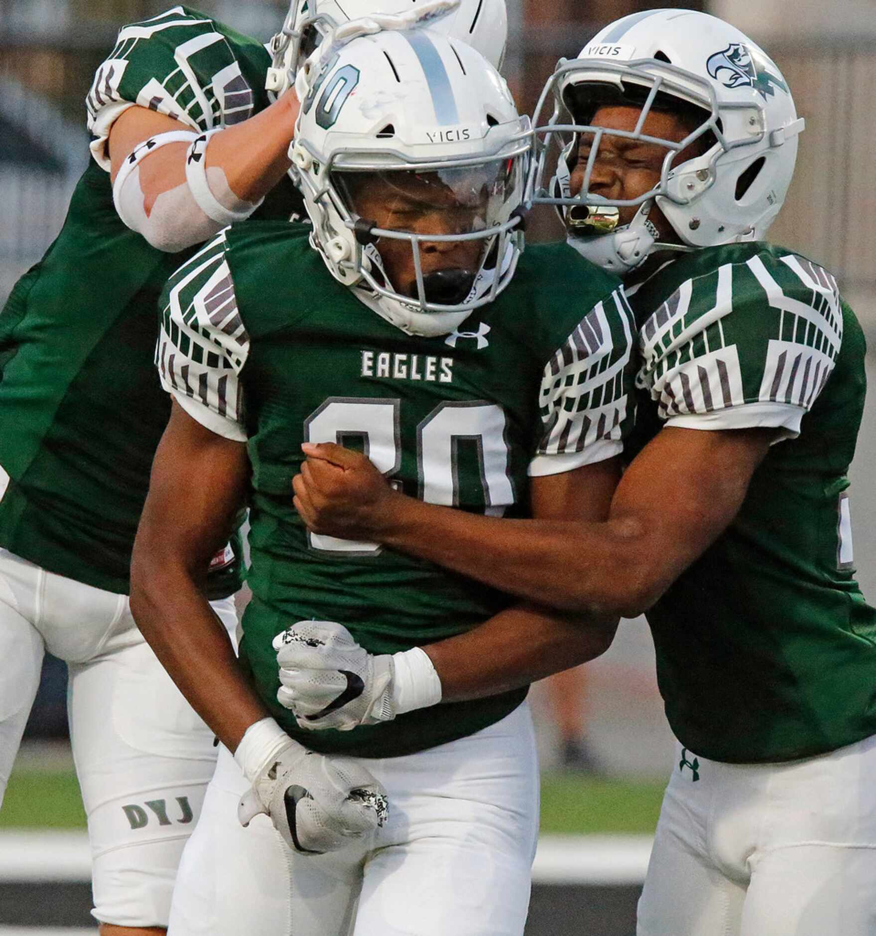 Prosper High School Bryson Propes (30) is congratulated by team mate Ryan Medeiros (16) and...