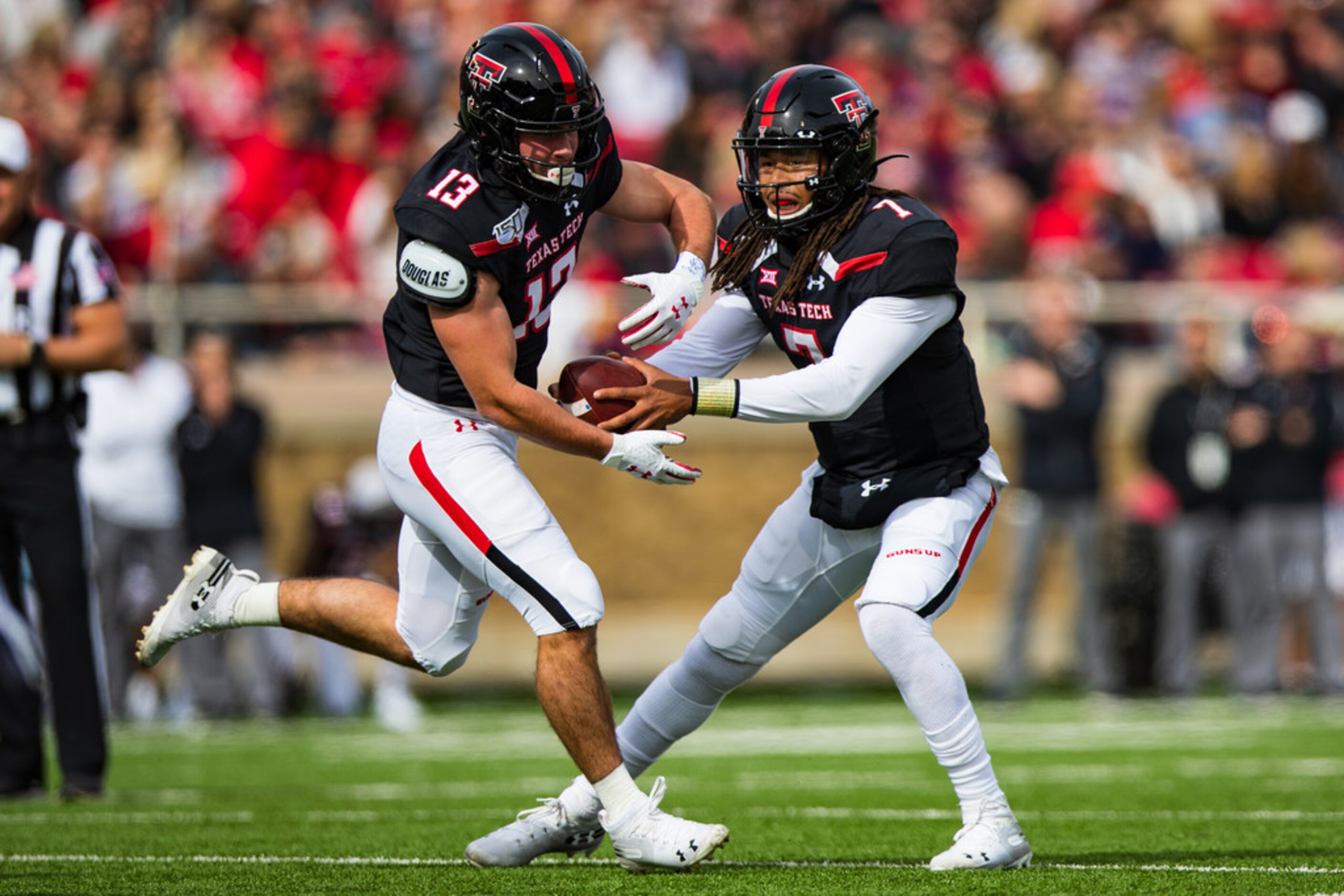 LUBBOCK, TEXAS - NOVEMBER 16: Quarterback Jett Duffey #7 of the Texas Tech Red Raiders fakes...