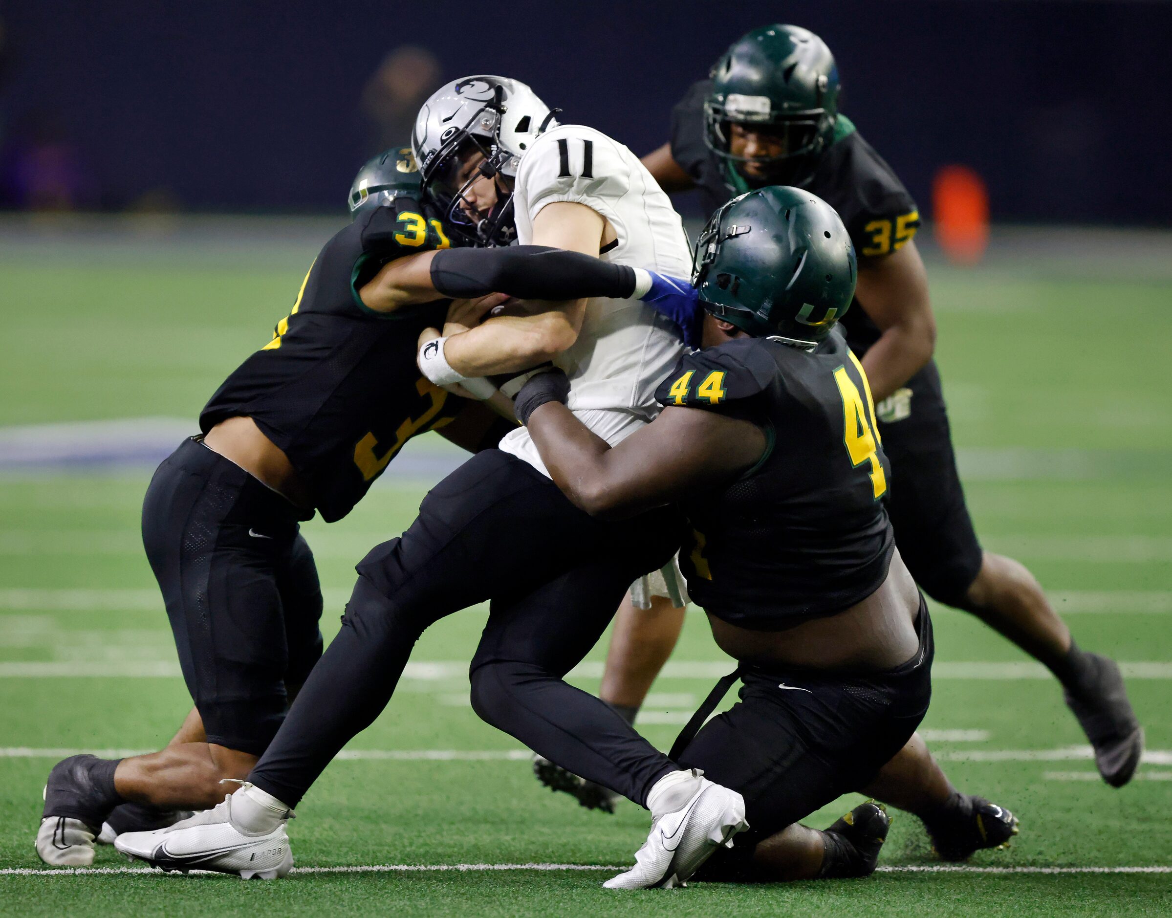 DeSoto outside linebacker Brandon Booker (31) and nose guard Marshall Kirven (44) sandwich...