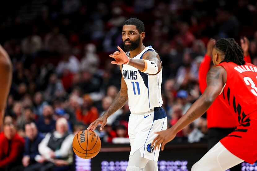 Dallas Mavericks guard Kyrie Irving gestures to teammates during the first half of their NBA...