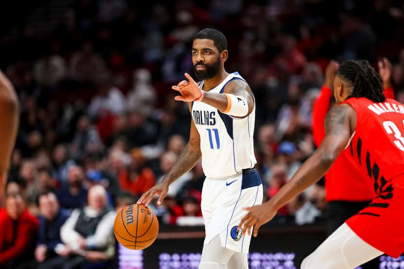 Dallas Mavericks guard Kyrie Irving gestures to teammates during the first half of their NBA...