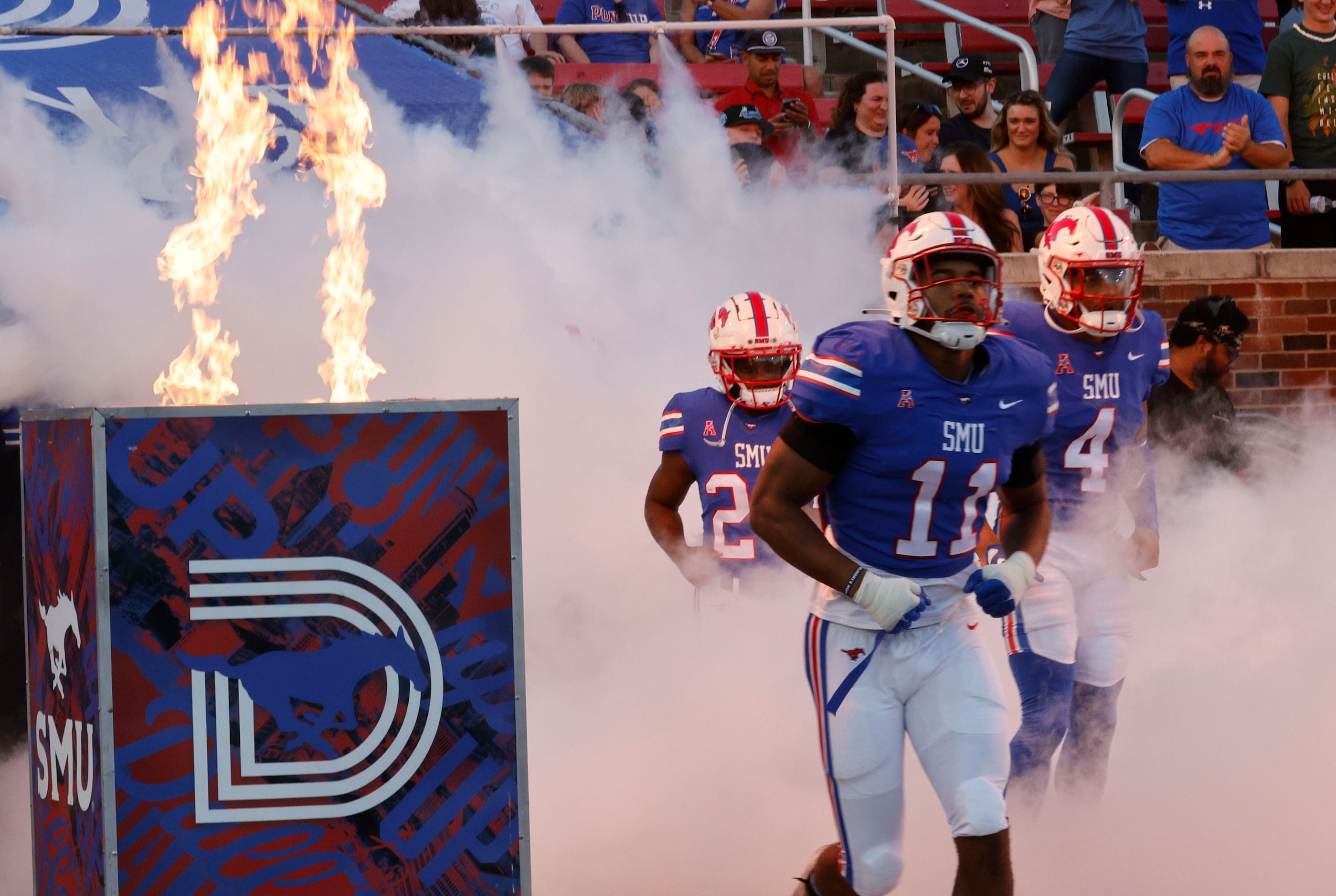 SMU players run into the field before an NCAA college football game against the Charlotte...