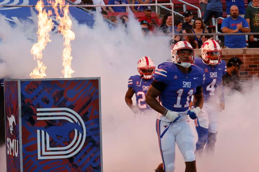 SMU players run into the field before an NCAA college football game against the Charlotte...