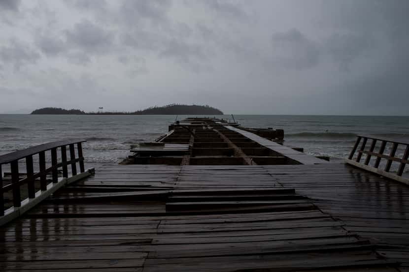 The remnant of Tropical Storm Beryl continues its way over a dock previously damaged by...