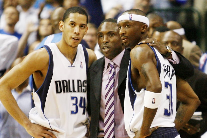 Mavericks coach Avery Johnson talks with Devin Harris and Jason Terry during a game at the...