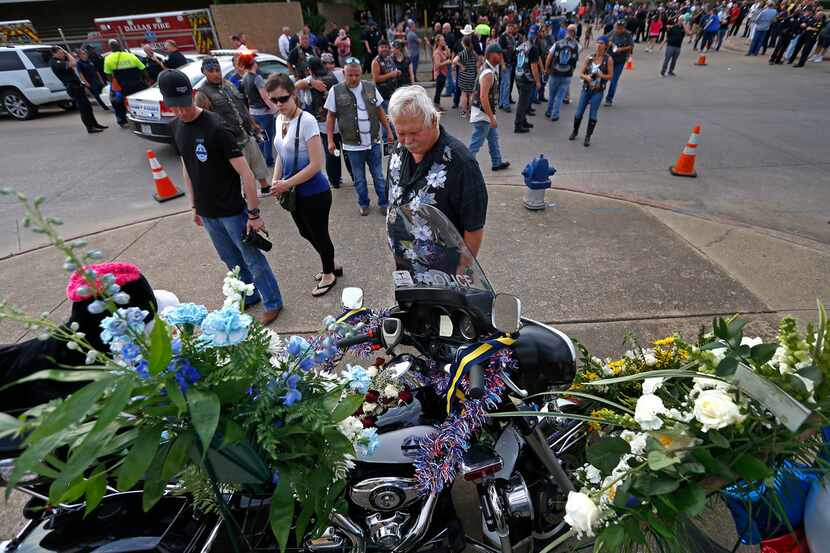 Retired Dallas police Officer Jack Bragg and others visit a memorial set for Senior Cpl....