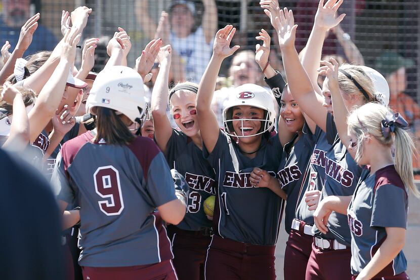 Ennis' Rylie Robertson (9) is congratulated by teammates at home plate after hitting a home...