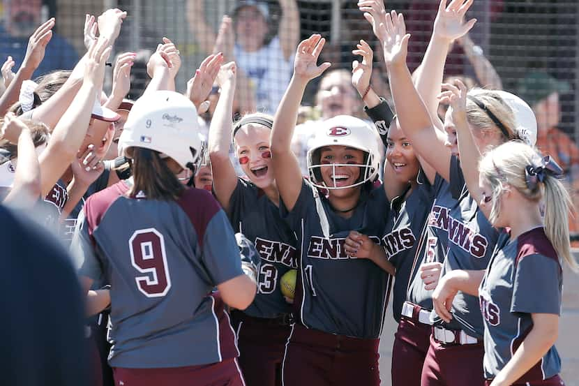 Ennis' Rylie Robertson (9) is congratulated by teammates at home plate after hitting a home...