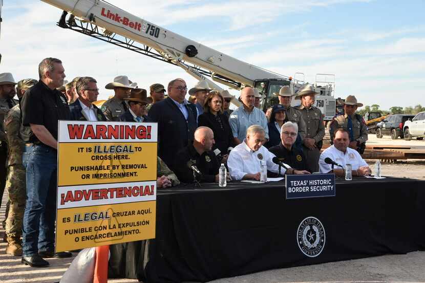 Gov. Greg Abbott signs three bills into law at a border wall construction site in...