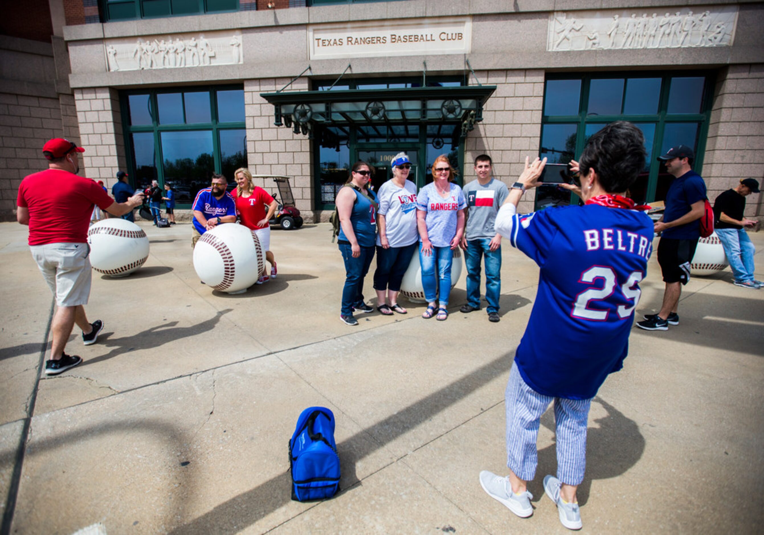 Fans pose for photos outside Globe Life Park before an opening day MLB game between the...