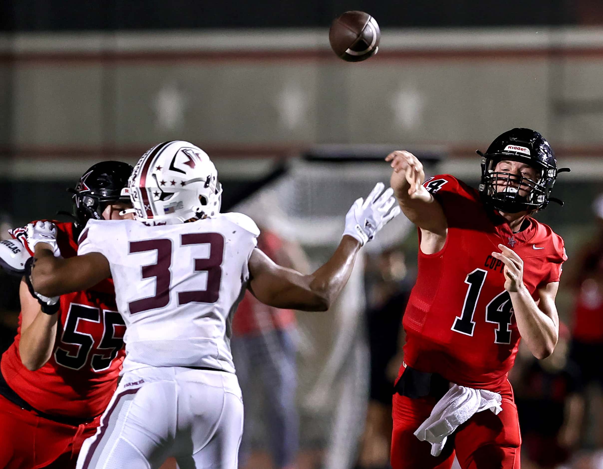 Coppell quarterback Edward Griffin (14) gets the pass off over Lewisville defensive lineman...