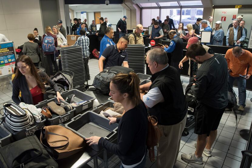 Travelers go through a TSA security entrance in Terminal C at DFW Airport.