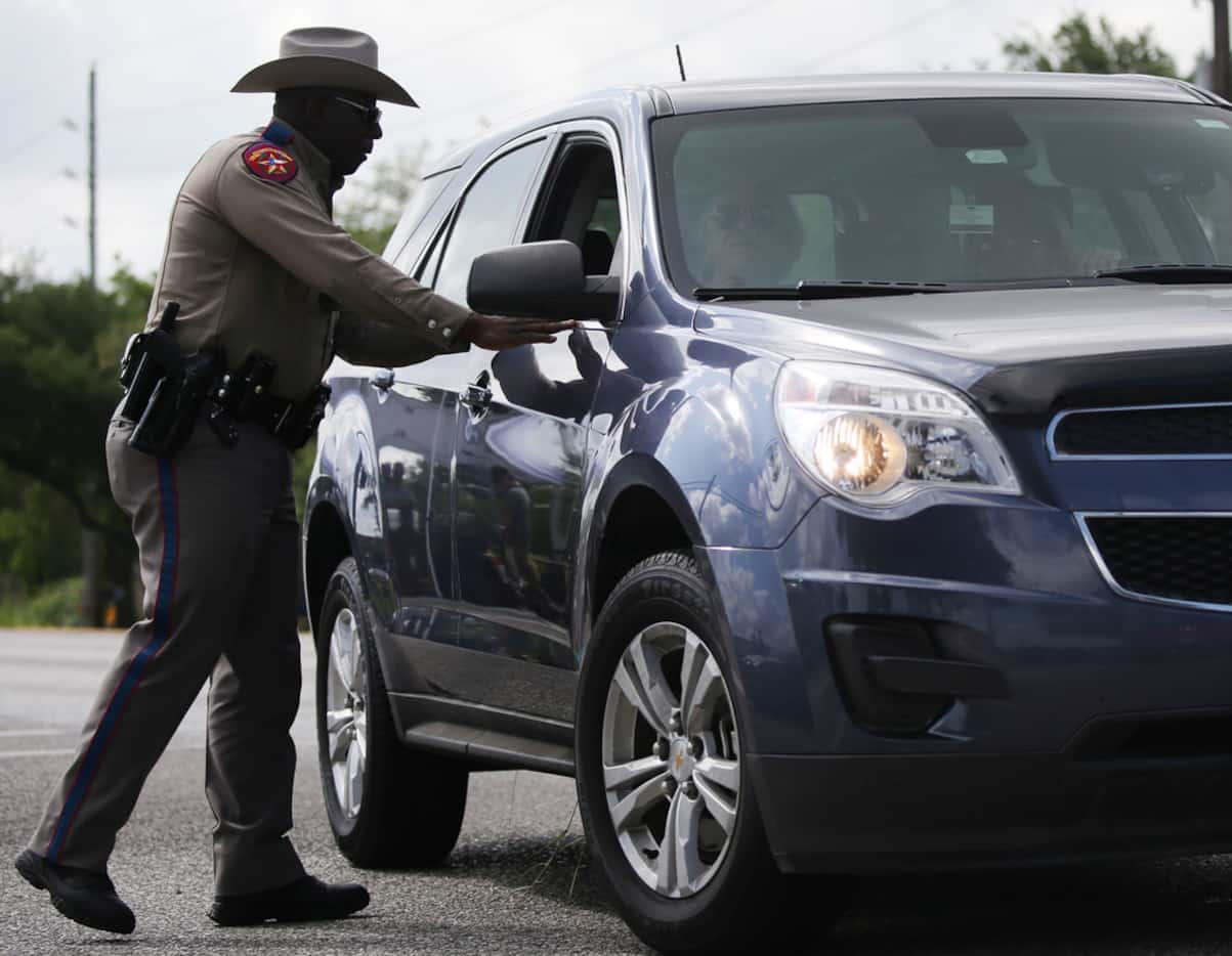 A Texas state trooper talks to drivers along State Highway 6 outside of Santa Fe High School.