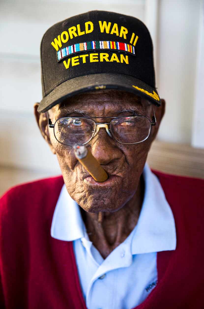 Richard Overton, 111, the oldest living U.S. war veteran, smokes a cigar on his front porch...