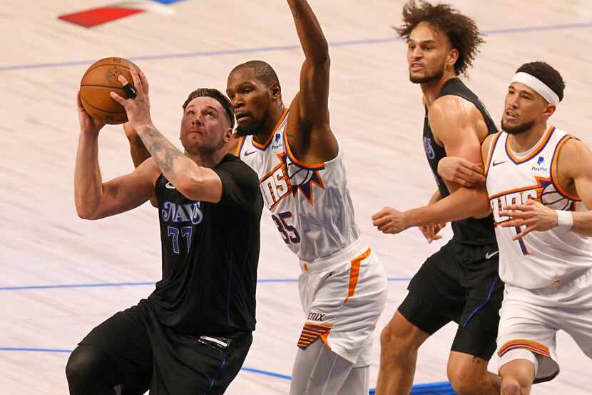 Dallas Mavericks guard Luka Doncic (77) attempts a jump shot as Phoenix Suns forward Kevin...