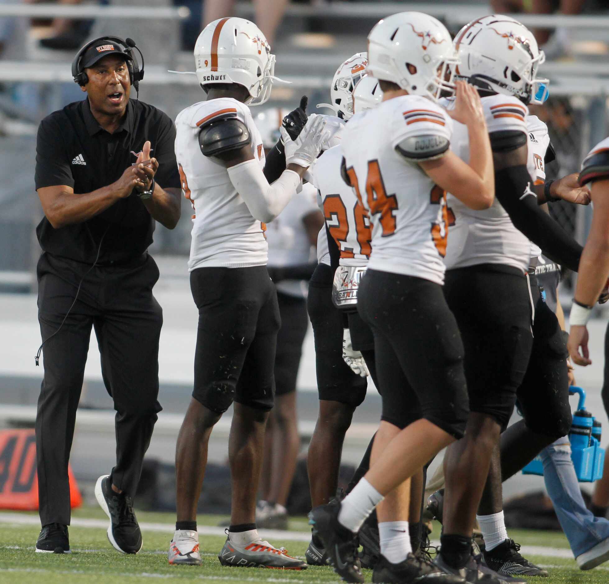W.T. White head coach Kenchee Ross, left, applauds his players during a timeout in the first...
