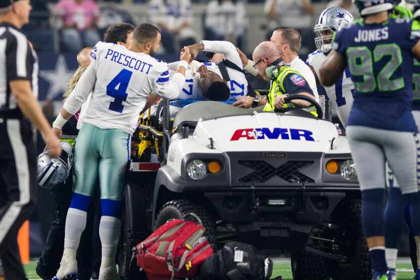 Dallas Cowboys wide receiver Allen Hurns (17) gets a handshake from quarterback Dak Prescott...