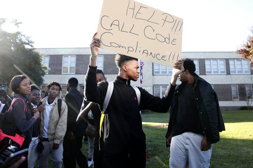 Student Kameron Davis held up a sign during a walkout protest against the building...