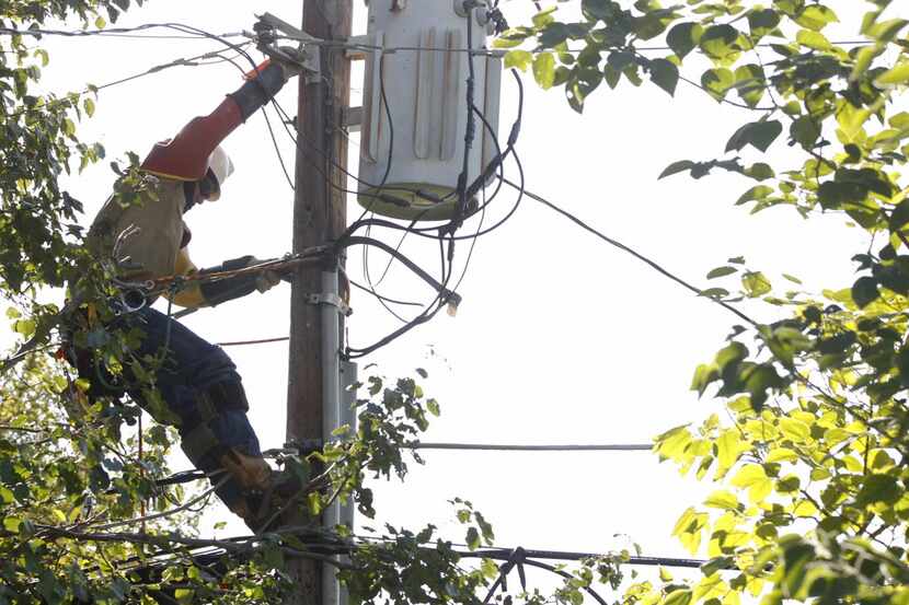 Oncor's Kutter Werning works on rewiring the power line to the transformer in Grand Prairie...
