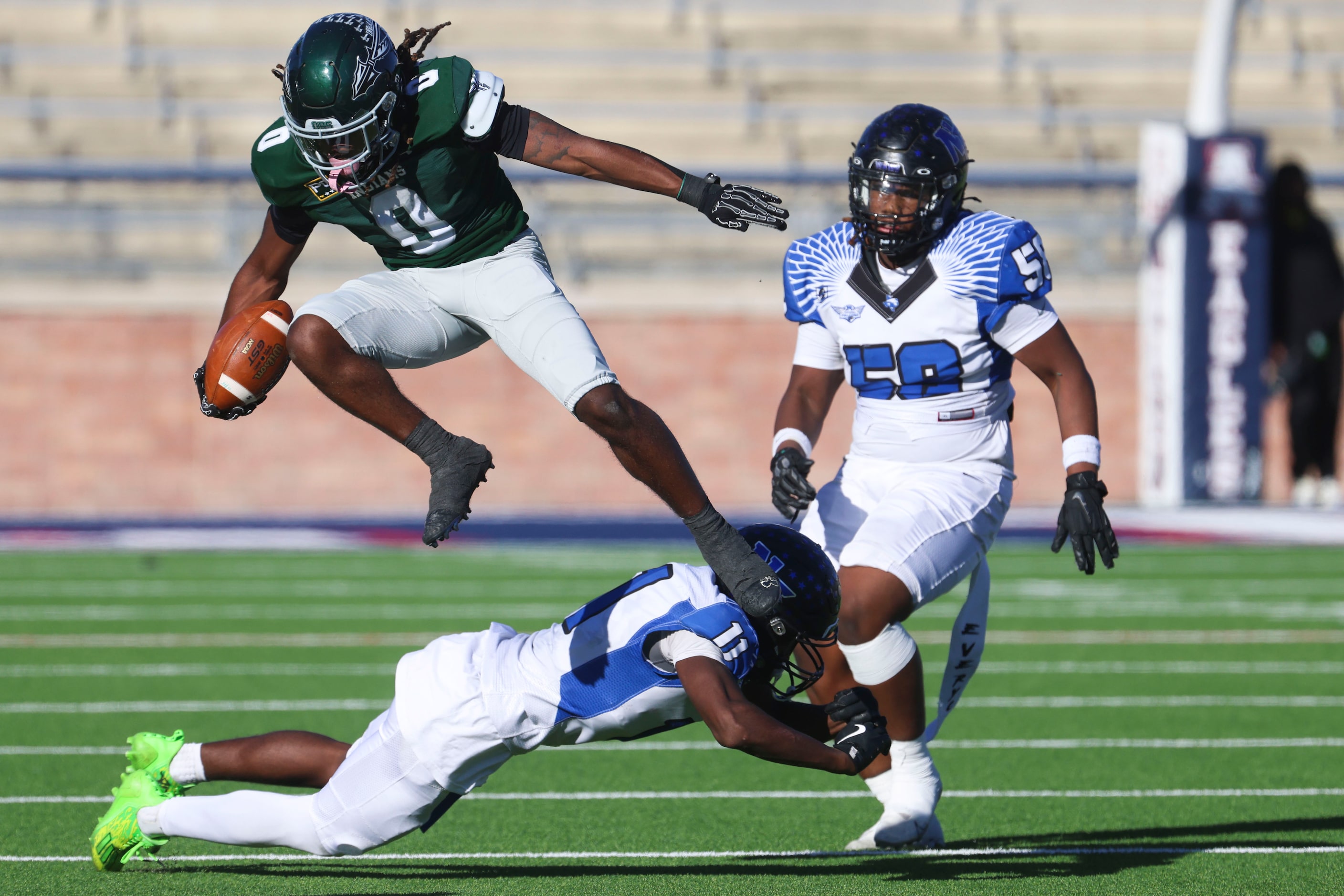 Waxahachie High’s Bryson Linnear (center) leaps over North Forney High’s Josiah Turner as he...