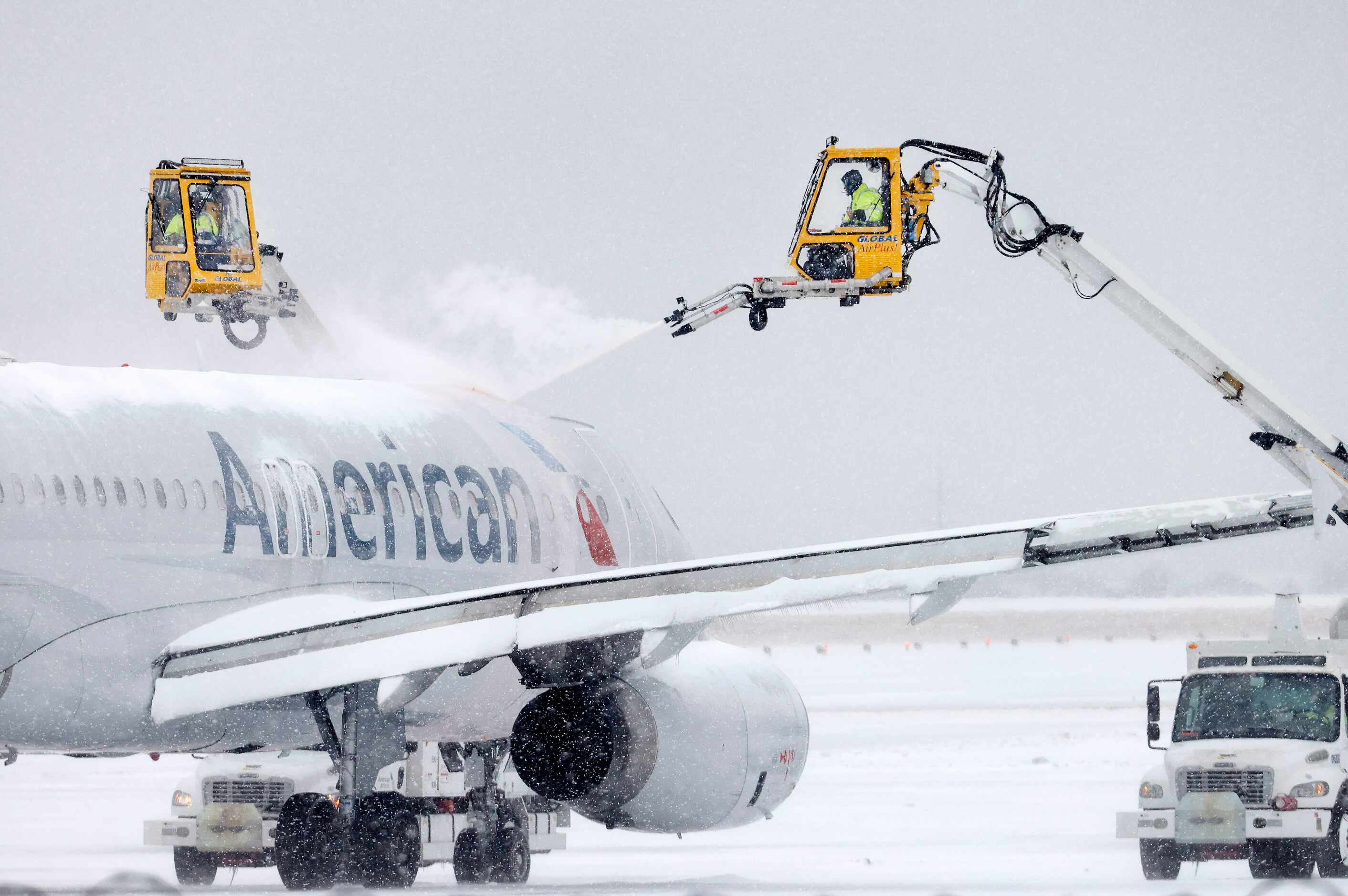 Aerial crews deice an American Airlines jet before it can take off at DFW Airport’s Terminal...