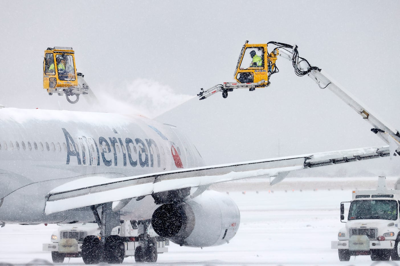 Aerial crews deice an American Airlines jet before it can take off at DFW Airport’s Terminal...
