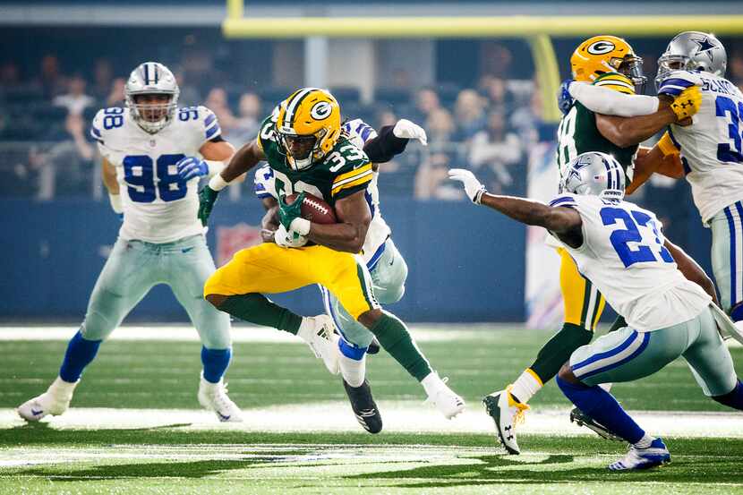 Green Bay Packers running back Aaron Jones (33) gets past Dallas Cowboys linebacker Jaylon...