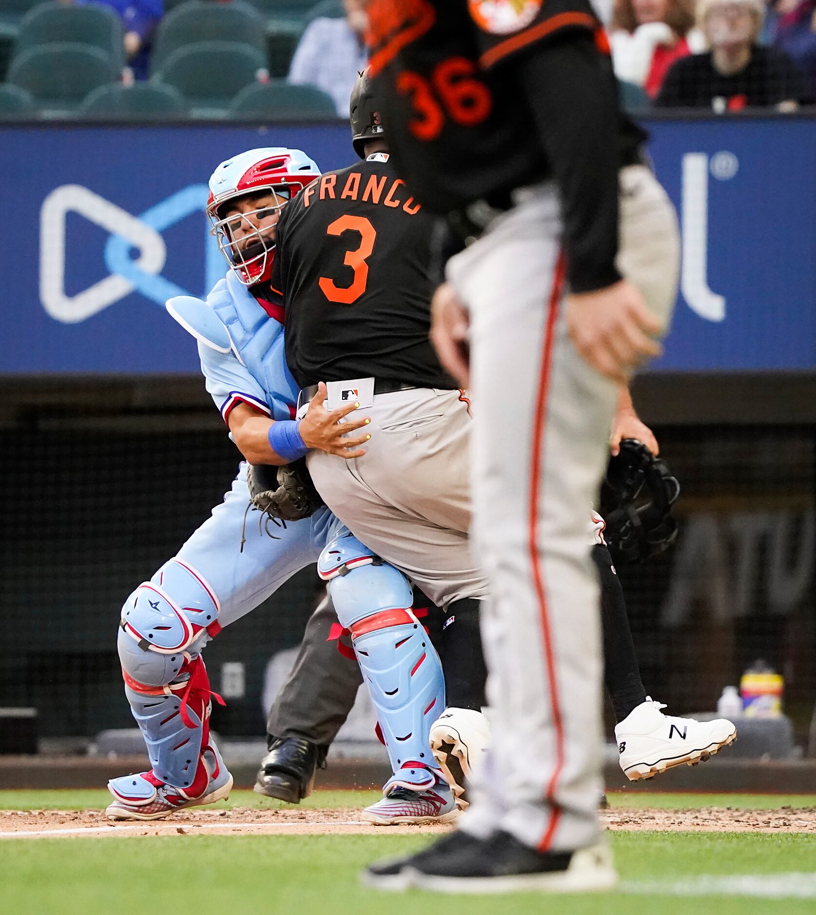 Texas Rangers catcher Jose Trevino holds on for the out on a collision with Baltimore...