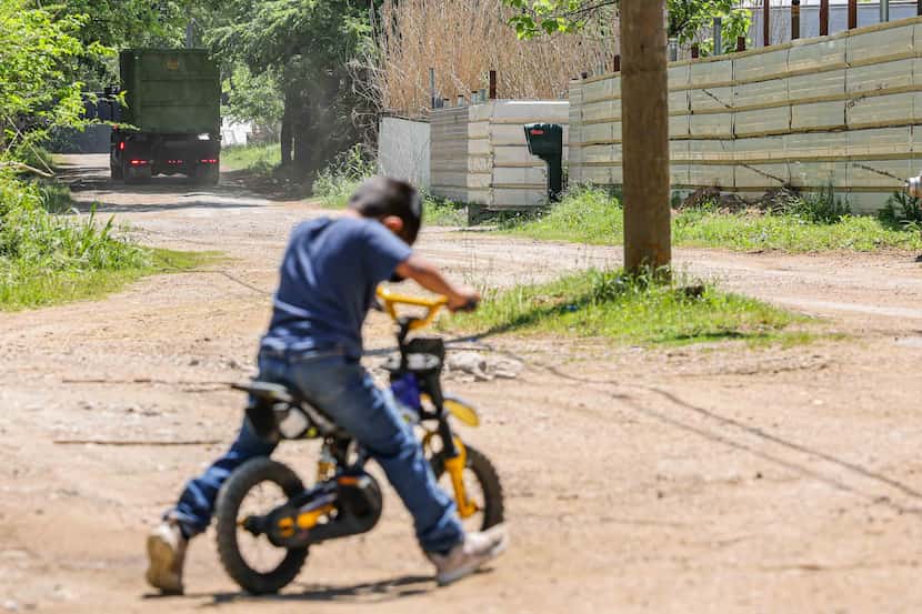 Five-year-old David Rojas rides his bike in front of his family's home on Bird Lane in the...