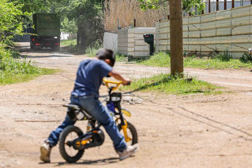 Five-year-old David Rojas rides his bike in front of his family's home on Bird Lane in the...