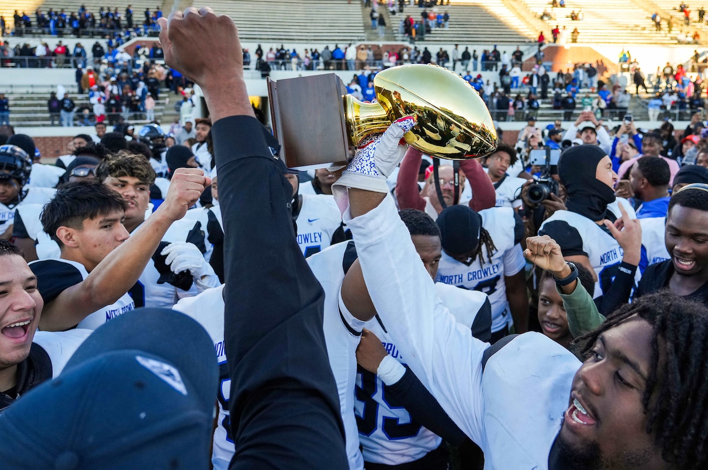 North Crowley offensive lineman Anthony Smith Jr. raises the game trophy after a victory...