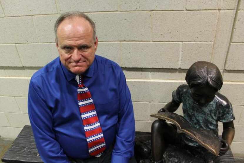 
Tom Keener sits next to a statue of a child reading outside the auditorium at the Allen...