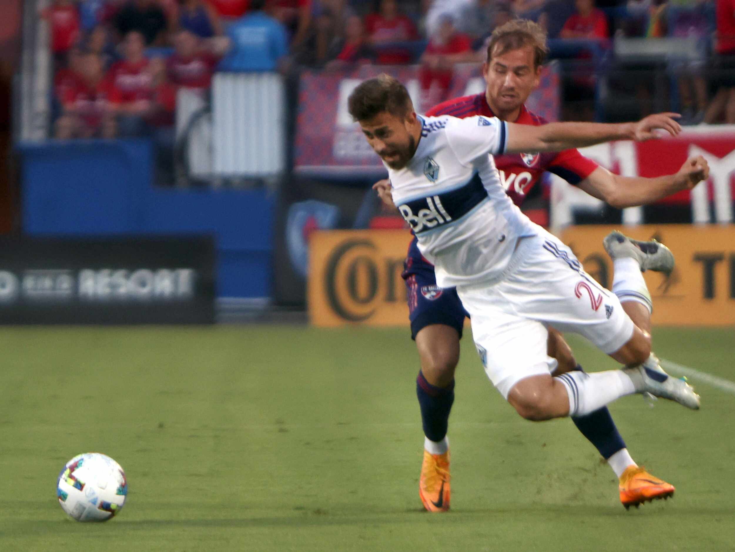 FC Dallas midfielder Paxton Pomykal (19), background, gets tangles with Vancouver's Marcus...