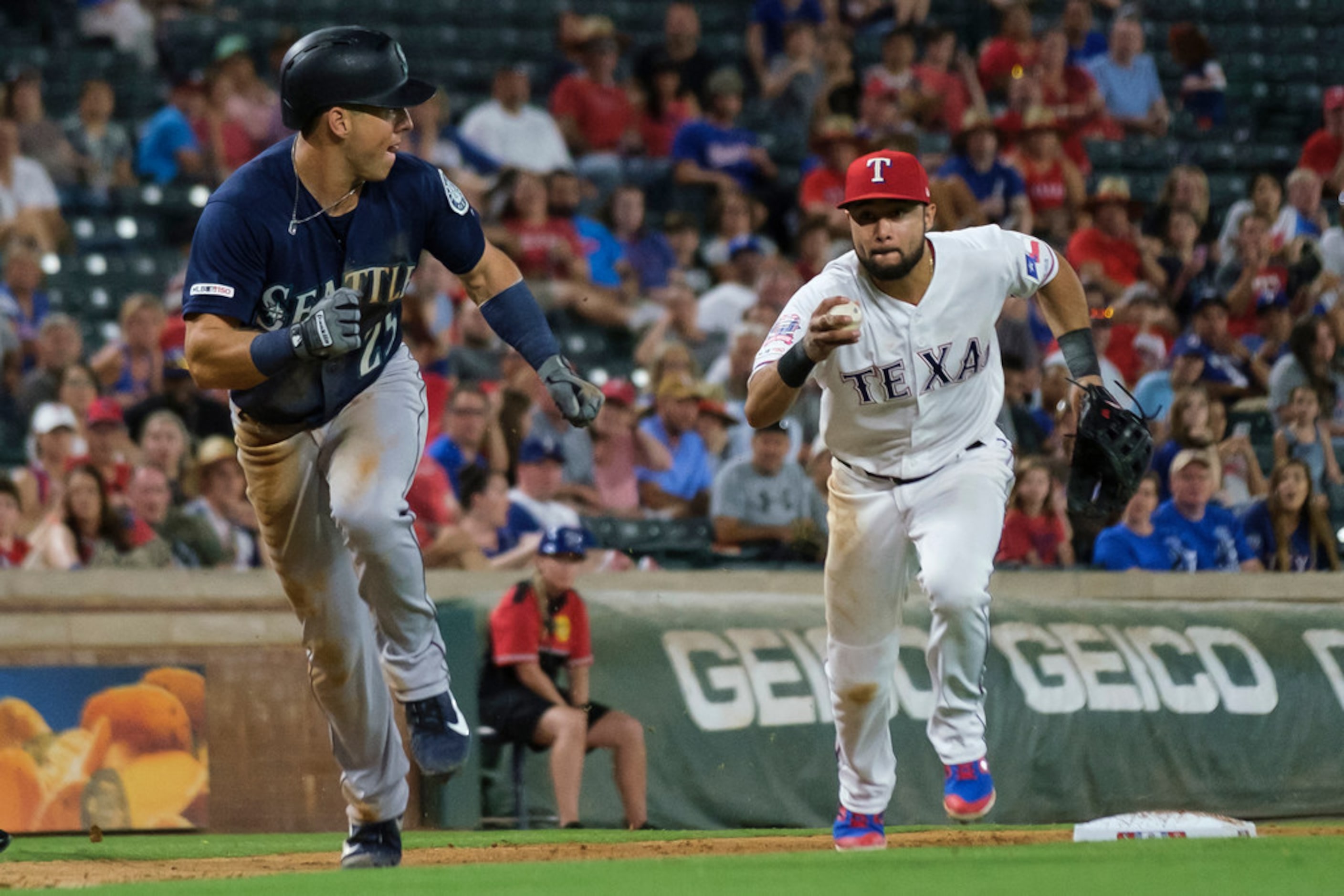 Seattle Mariners shortstop Dylan Moore gets caught in a rundown by Texas Rangers third...