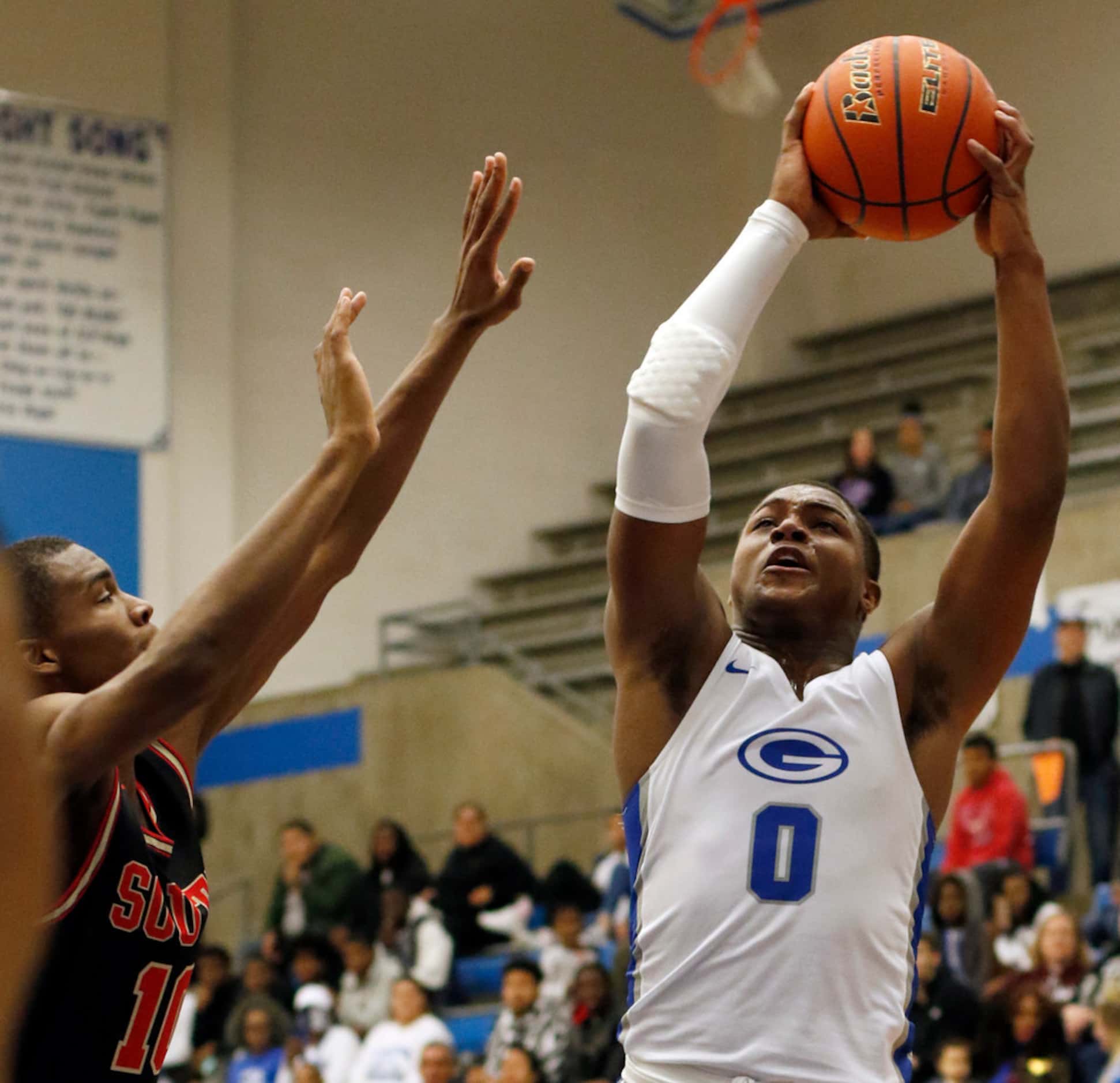 Grand Prairie's Savion Red (0) drives to the basket as he is defended by South Grand...