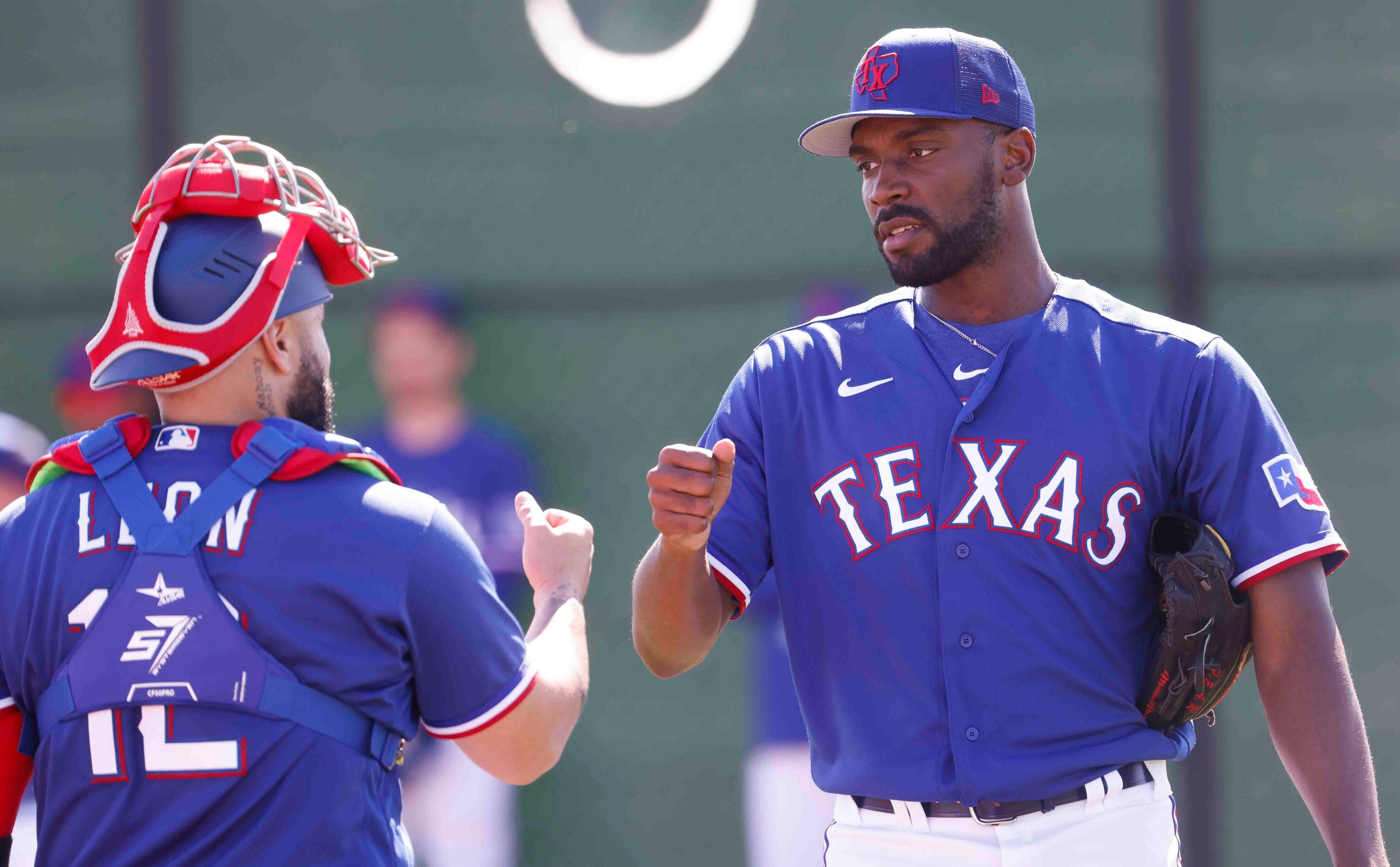 Texas Rangers catcher Sandy Leon, left, fist bumps with pitcher Taylor Hearn after a...