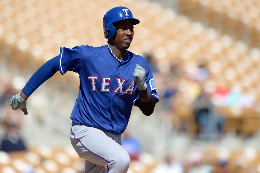 Rangers shortstop Jurickson Profar (right) runs to first after hitting a grounder up the...