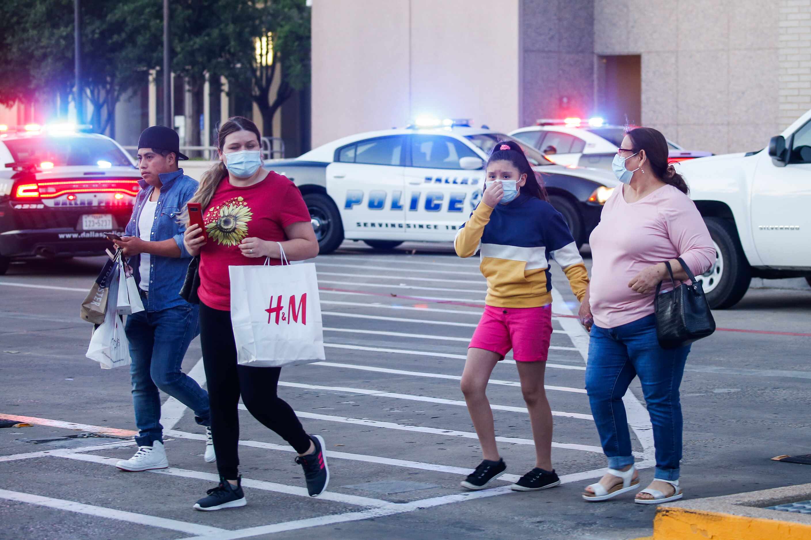 People are escorted out of Galleria Dallas mall, where a shooting was reported Tuesday, June...