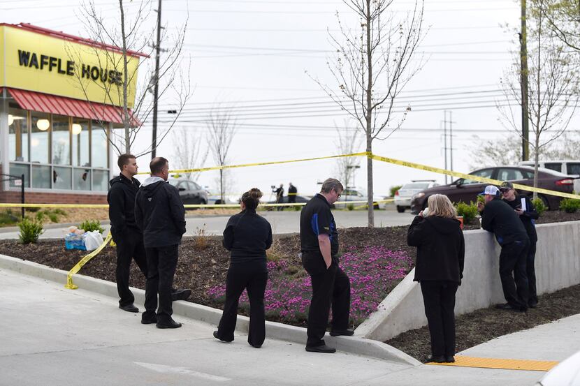 Law enforcement officials work the scene of a fatal shooting at a Waffle House in the...