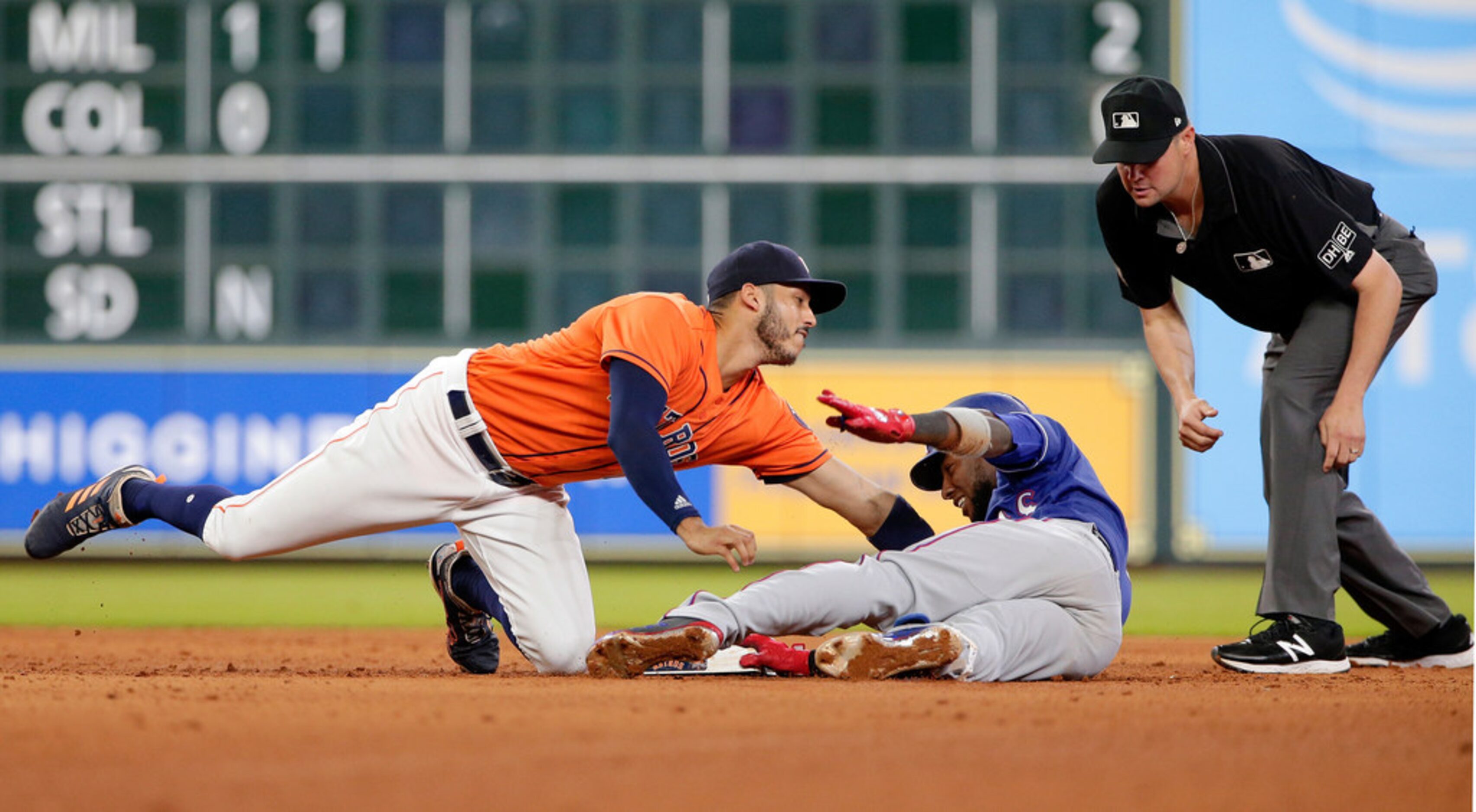 Houston Astros shortstop Carlos Correa, left, attempts the tag at second base on Texas...