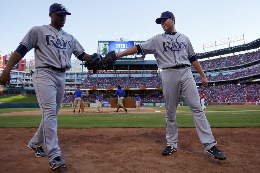 Tampa Bay Rays starting pitcher Matt Moore, right, gives a tap to teammate Desmond Jennings...